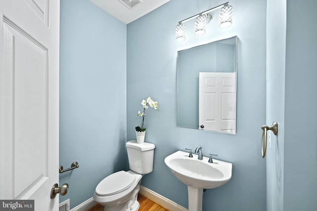 bathroom with sink, hardwood / wood-style floors, and toilet