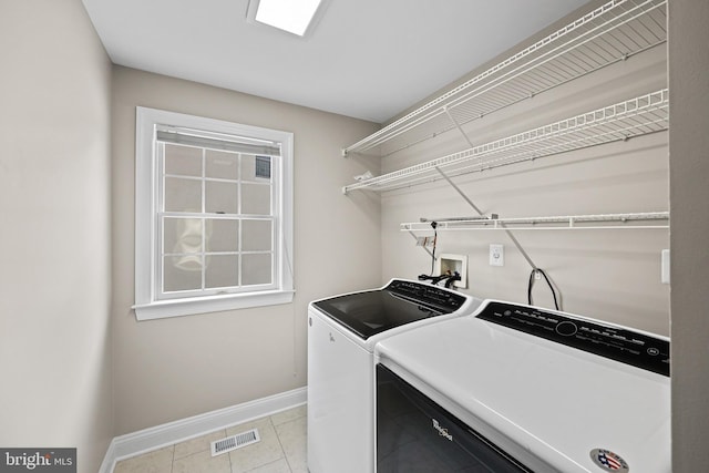 laundry room with washing machine and dryer and light tile patterned flooring