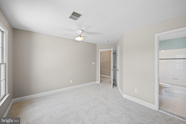 unfurnished bedroom with light colored carpet, ceiling fan, and ensuite bathroom