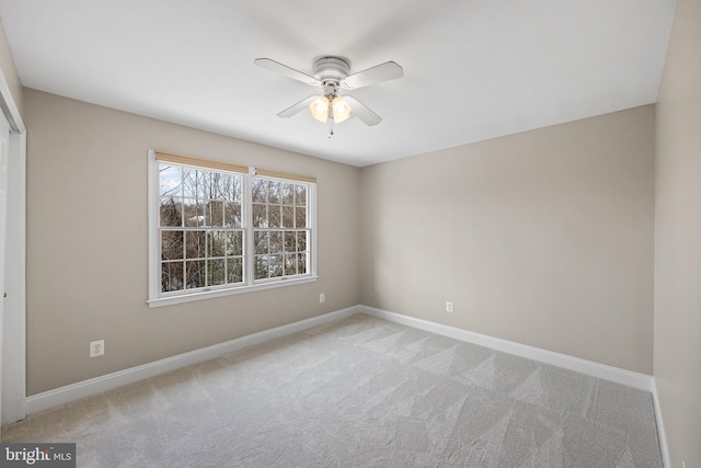 empty room with ceiling fan and light carpet