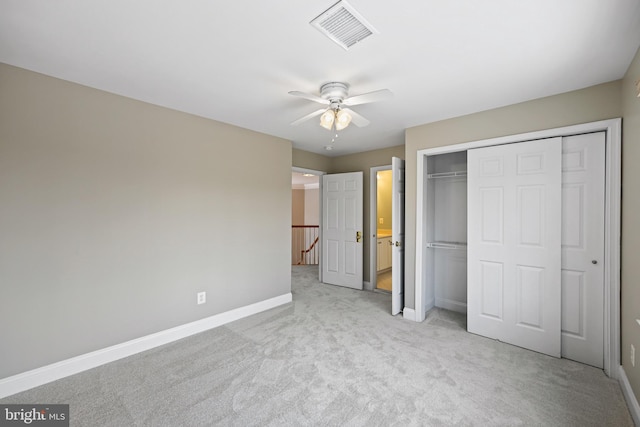 unfurnished bedroom featuring light colored carpet, ceiling fan, and a closet