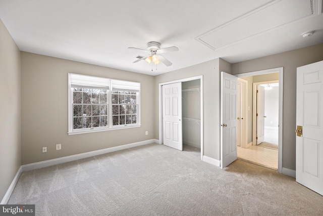 unfurnished bedroom with ceiling fan, light carpet, and a closet