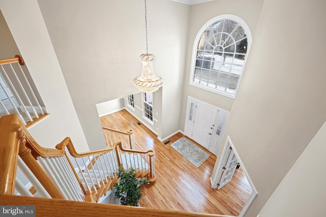 foyer with hardwood / wood-style flooring and a towering ceiling