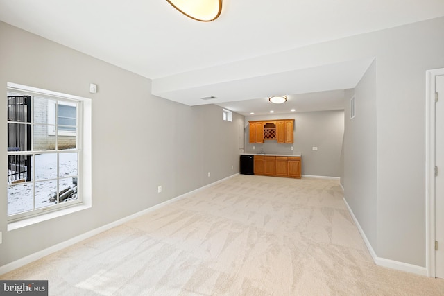 unfurnished living room featuring sink and light colored carpet