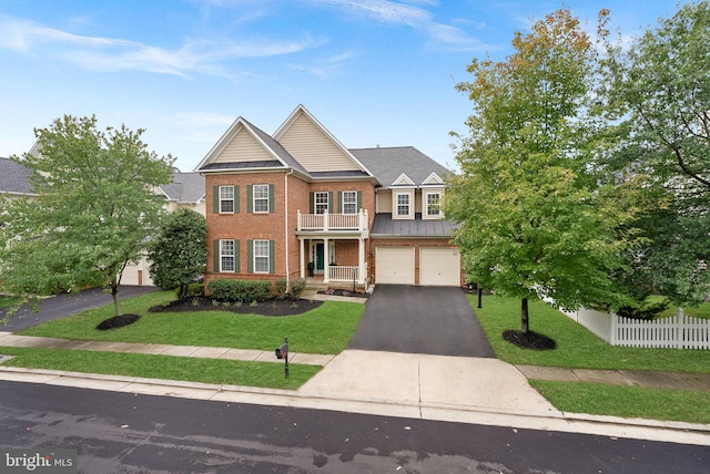 view of front of home with a garage, a front yard, and a balcony