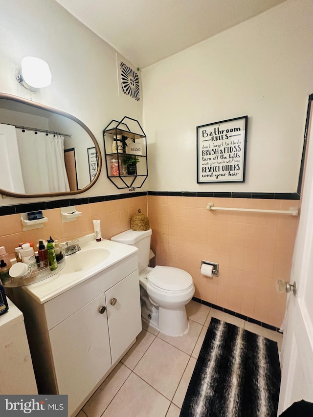 bathroom featuring tile walls, vanity, tile patterned floors, and toilet