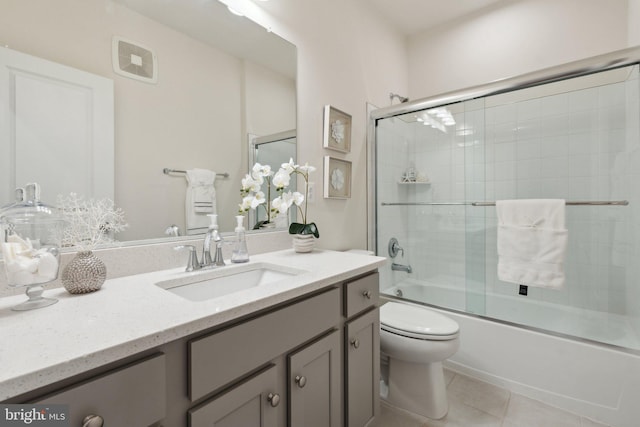 full bathroom featuring vanity, toilet, tile patterned flooring, and combined bath / shower with glass door