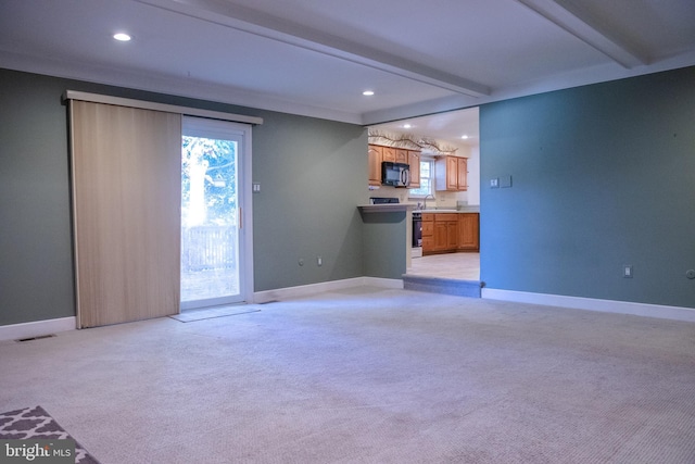 unfurnished living room with light carpet, crown molding, beam ceiling, and sink