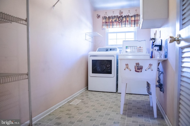 clothes washing area featuring sink and washer and dryer