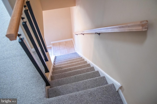 staircase featuring tile patterned flooring