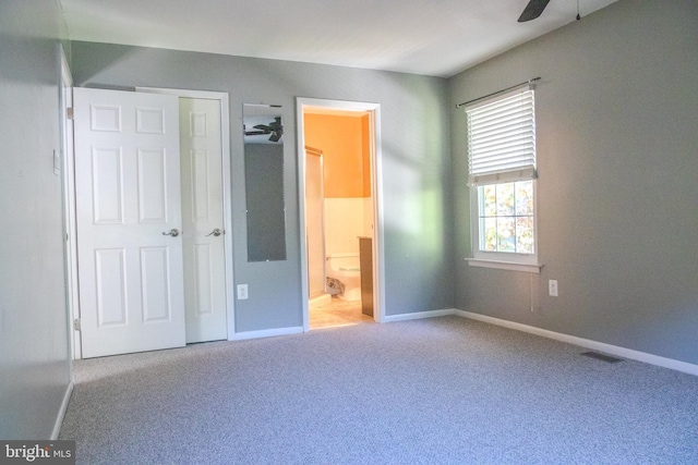 unfurnished bedroom with ceiling fan, ensuite bathroom, and carpet floors