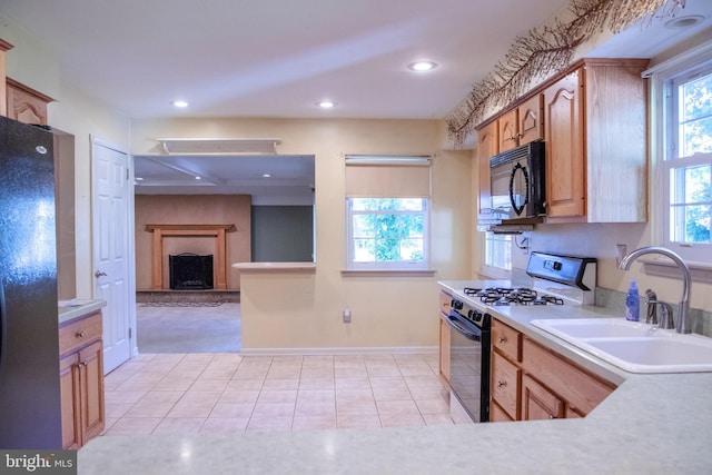 kitchen with light tile patterned floors, sink, and black appliances