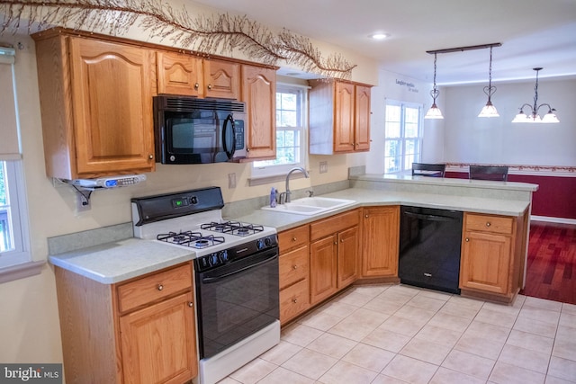 kitchen with pendant lighting, black dishwasher, sink, kitchen peninsula, and gas range oven