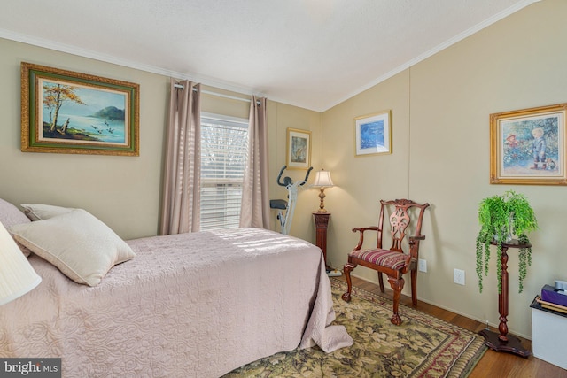 bedroom featuring hardwood / wood-style floors, crown molding, and vaulted ceiling