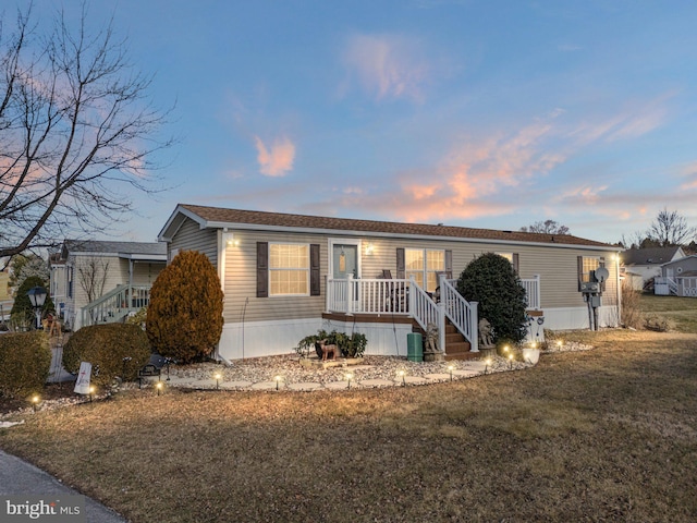 manufactured / mobile home featuring a lawn and central AC