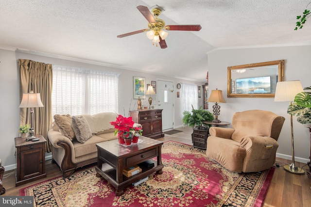 living room with vaulted ceiling, ceiling fan, a healthy amount of sunlight, and hardwood / wood-style floors