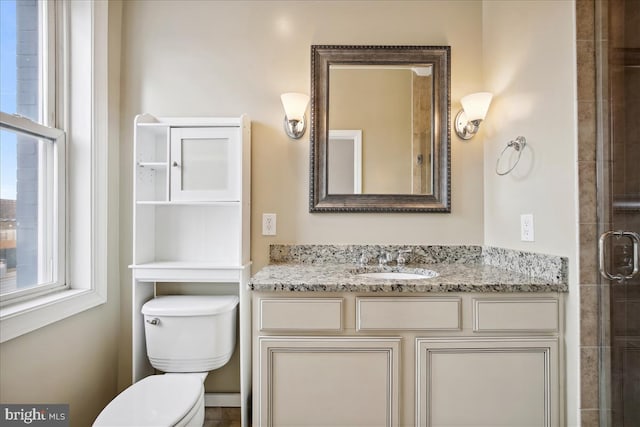 full bathroom with toilet, a tile shower, and vanity