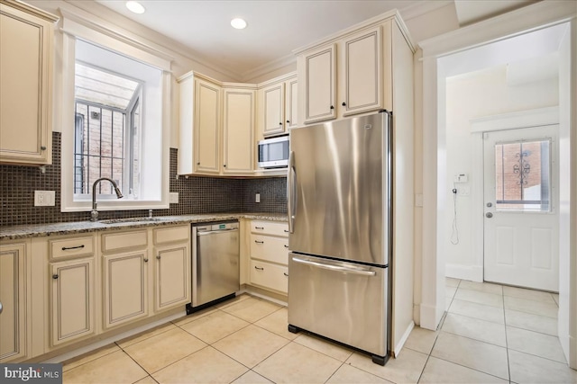 kitchen featuring sink, light tile patterned floors, stainless steel appliances, and dark stone countertops