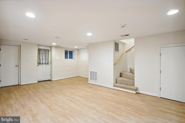 finished below grade area featuring recessed lighting, visible vents, and light wood-style floors