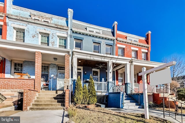 multi unit property featuring covered porch and brick siding