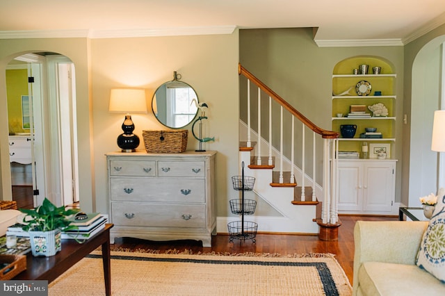 living room featuring hardwood / wood-style flooring, ornamental molding, and built in shelves