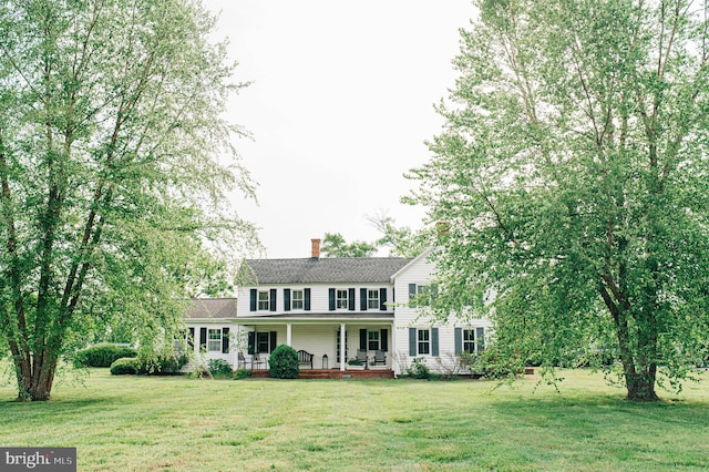 colonial home with covered porch and a front lawn