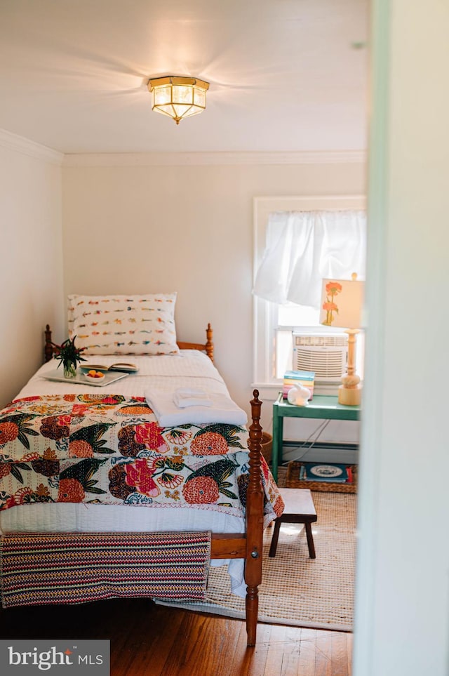 bedroom with cooling unit, hardwood / wood-style floors, and ornamental molding