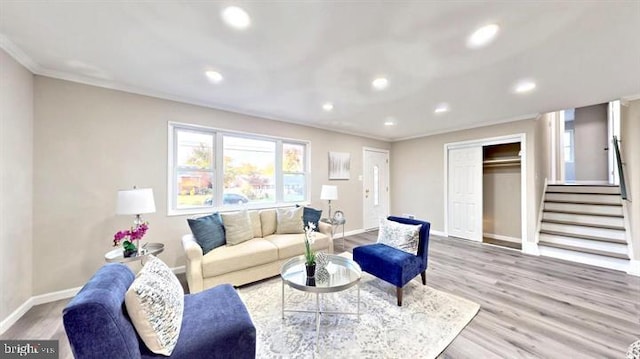 living room with light hardwood / wood-style floors and crown molding