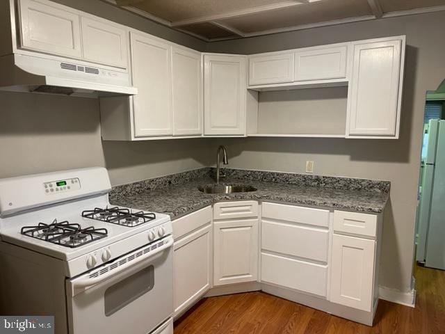 kitchen with white appliances, dark wood-type flooring, white cabinets, and sink