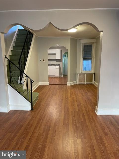 interior space with radiator and hardwood / wood-style flooring