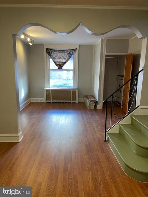 spare room featuring ornamental molding and wood-type flooring