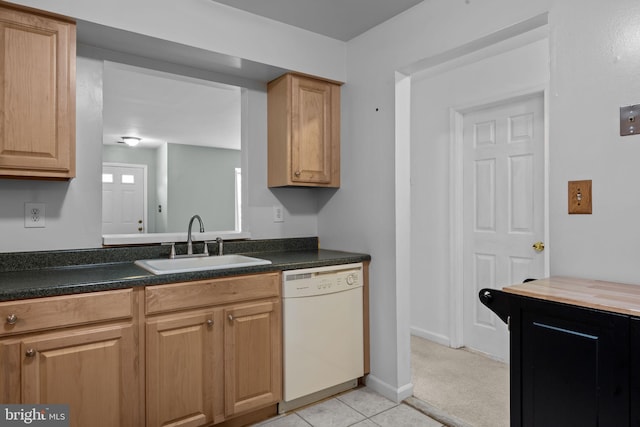 kitchen with light tile patterned floors, sink, and white dishwasher