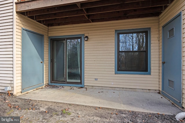 view of exterior entry featuring a patio area