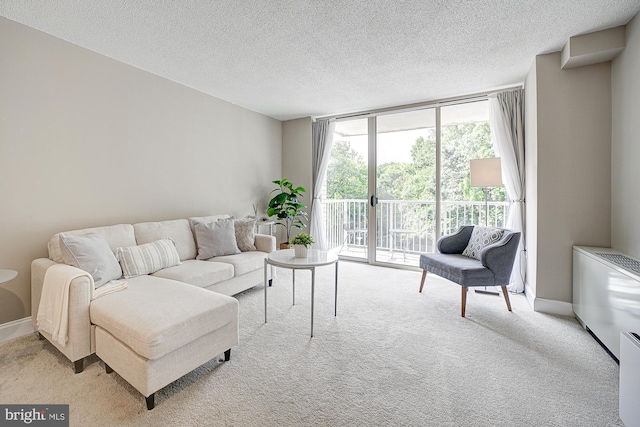 living room with expansive windows, light carpet, and a textured ceiling