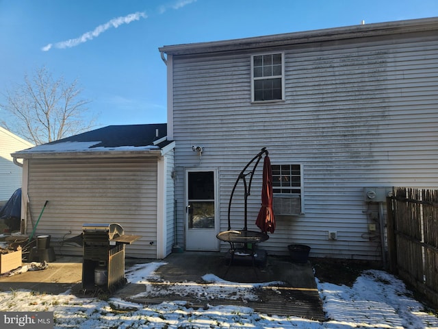 snow covered rear of property featuring a patio area