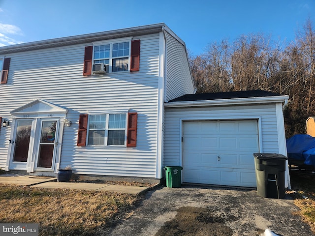 view of property with cooling unit and a garage