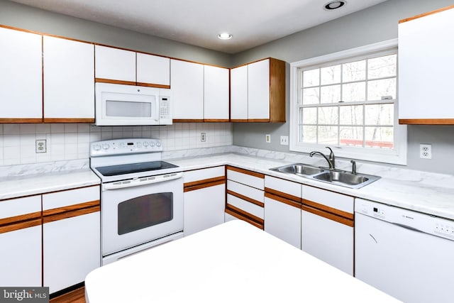 kitchen featuring light countertops, white appliances, a sink, and white cabinetry