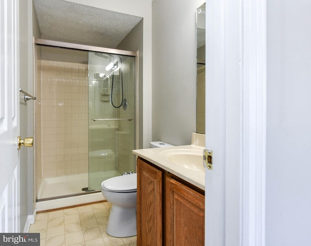 bathroom with a shower stall, a textured ceiling, toilet, and vanity