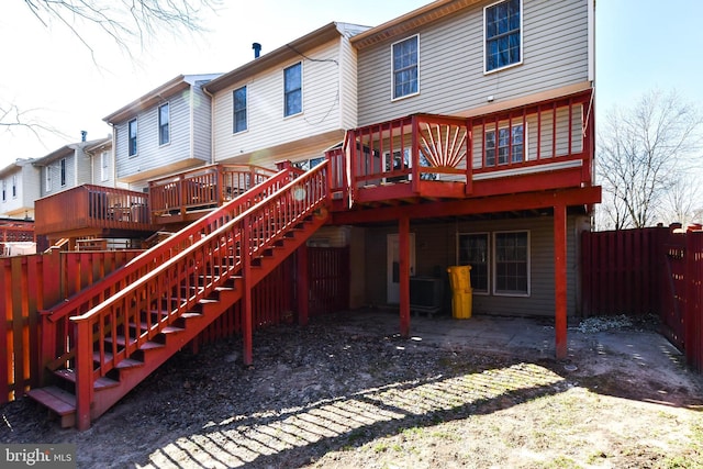 back of property with a patio area, fence, a wooden deck, and stairs