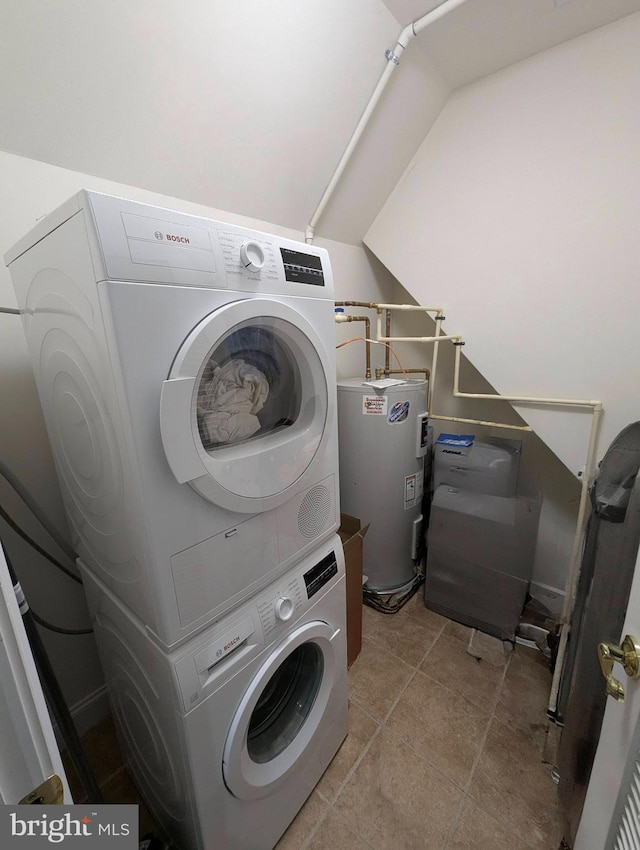 clothes washing area with light tile patterned flooring, stacked washer / dryer, and water heater