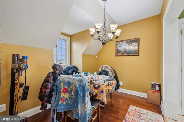 dining space featuring vaulted ceiling, wood-type flooring, and a chandelier