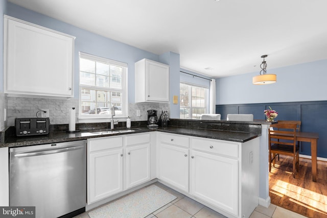 kitchen featuring sink, white cabinets, stainless steel dishwasher, and kitchen peninsula