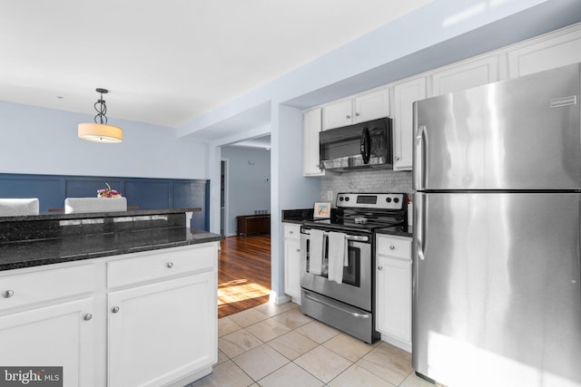 kitchen featuring decorative light fixtures, tasteful backsplash, white cabinetry, light tile patterned floors, and stainless steel appliances