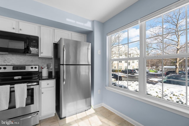 kitchen with tasteful backsplash, white cabinetry, light tile patterned floors, and stainless steel appliances