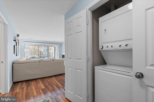 washroom with stacked washer / drying machine and dark hardwood / wood-style floors