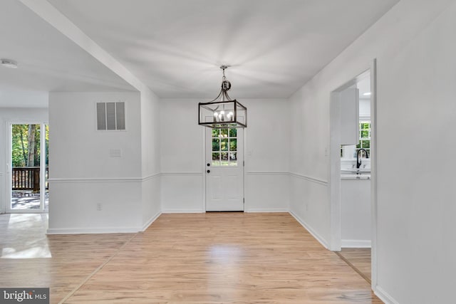 entrance foyer featuring light hardwood / wood-style flooring and an inviting chandelier