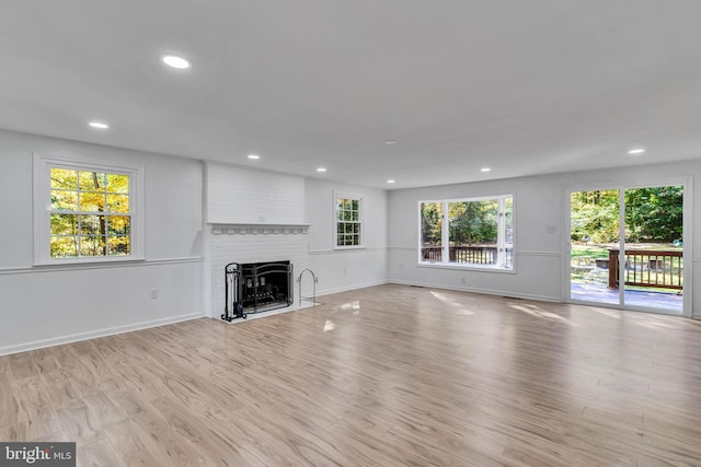 unfurnished living room with a fireplace and light hardwood / wood-style floors