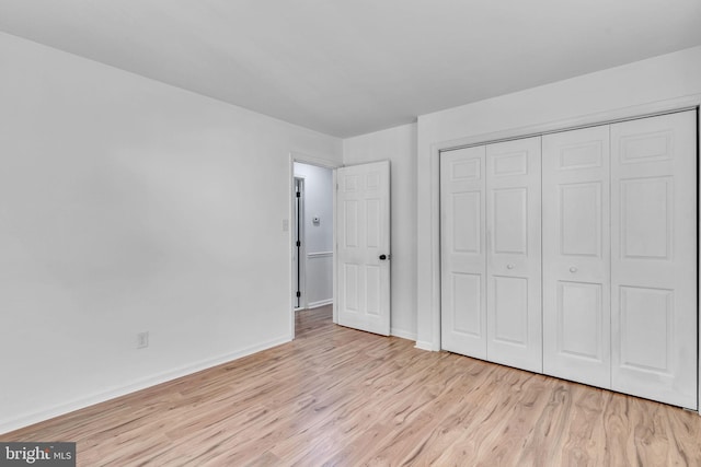 unfurnished bedroom with a closet and light hardwood / wood-style floors