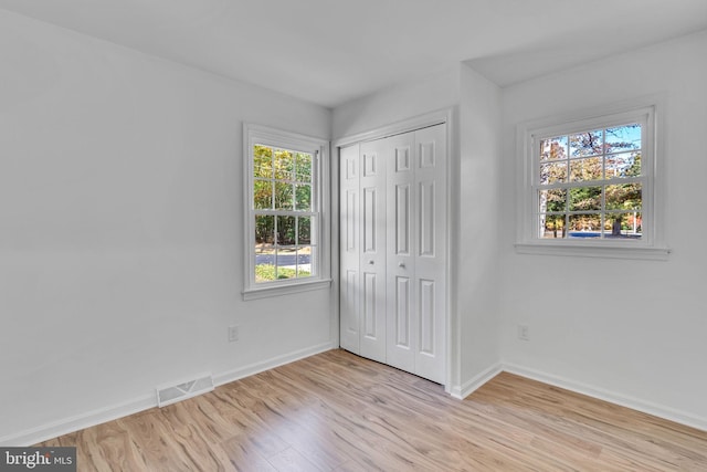 unfurnished bedroom featuring a closet and light hardwood / wood-style flooring