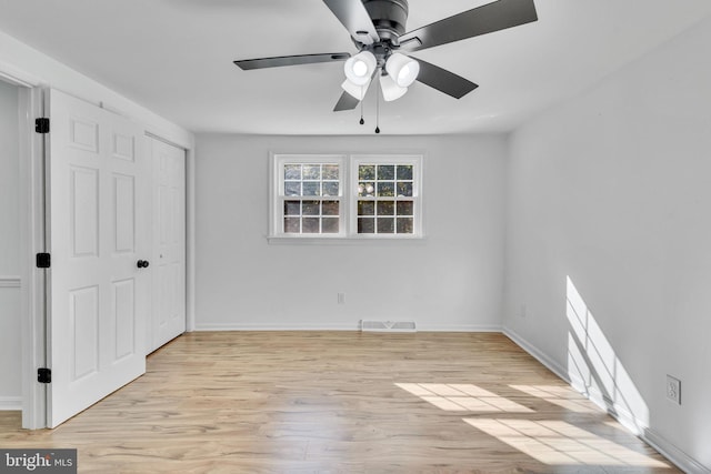 unfurnished bedroom featuring light wood-type flooring, ceiling fan, and a closet